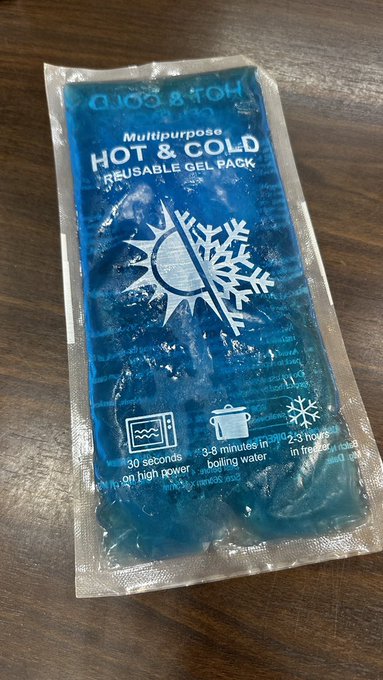 Photograph of a blue 'Multipurpose HOT & COLD Reusable Gel Pack' by Hot & Squa in sealed plastic packaging, resting on a wooden surface.