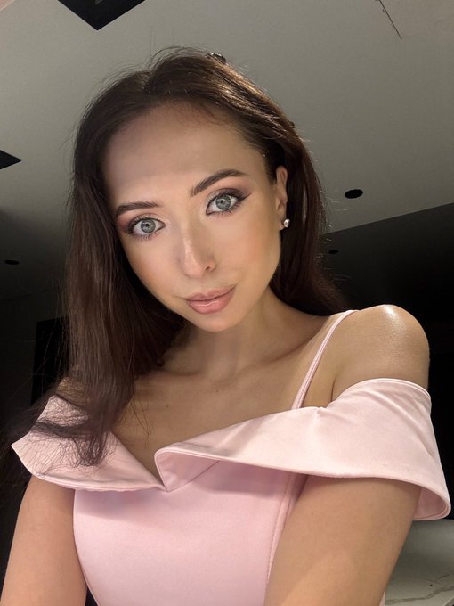 A selfie of a woman with long dark hair, striking blue-green eyes, and pink eyeshadow, wearing a pale pink off-the-shoulder top. The image accompanies an introduction post where Anna presents herself as a Ukrainian-born tech founder and investor newly relocated to San Francisco.
