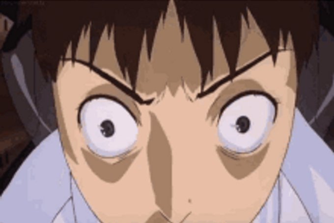 A close-up anime screenshot of a character with wide, shocked eyes and a serious expression, likely from a suspenseful scene.