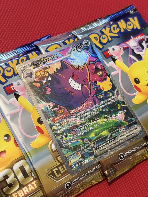 A Pokémon trading card featuring Gengar ex with the attacks 'Fainting Spell' and 'Chaotic Rain' rests on top of two Pokémon Trading Card Game booster packs.