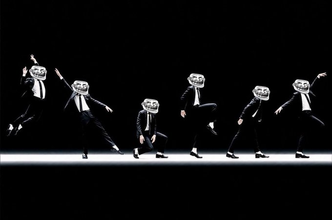The image features a series of five people wearing suits, each with a different expression or pose, all dancing together. The first person has their arms raised high above their head, while the others follow suit. The poses are dynamic and varied, showcasing the dancers' energy and enthusiasm for the performance.
