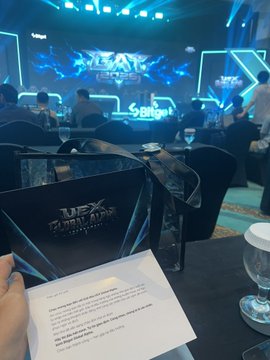 Photo taken inside a gaming tournament venue branded "UFL" with stage lighting and signage visible in the background.