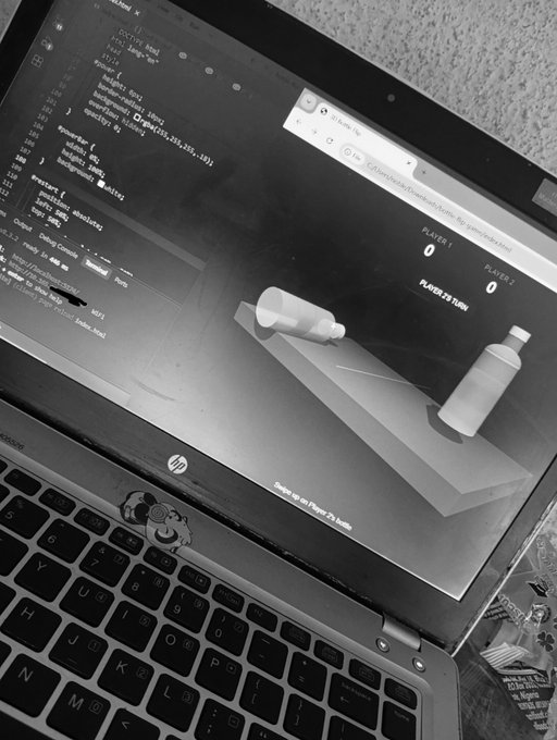 A black-and-white photo of an HP laptop displaying code on the left side of the screen and a 3D animation of bowling pins and a bottle on the right, suggesting a physics simulation program.