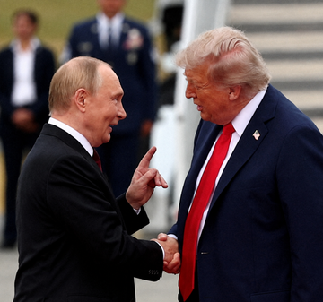 Vladimir Putin and Donald Trump shake hands and appear engaged in an intense conversation, reportedly during peace talks where Putin pitched a $20 billion deal involving Lukoil's global oil assets to Trump's envoys at the Kremlin in September.