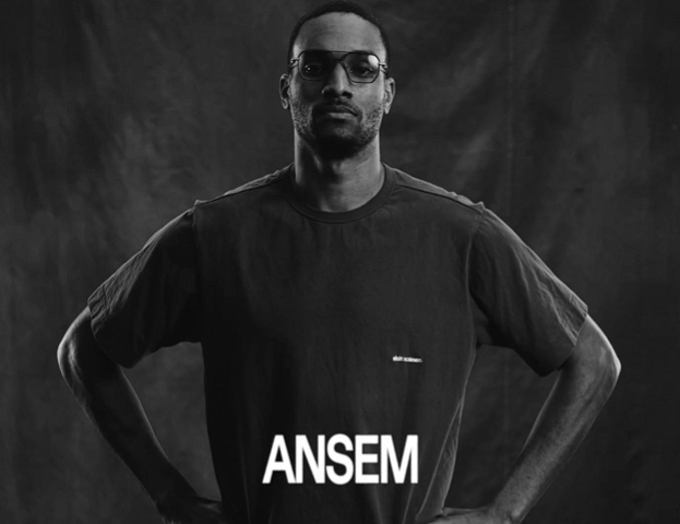 A black-and-white portrait of a man in glasses and a black t-shirt, with the name "ANSEM" displayed in large white letters across his chest.