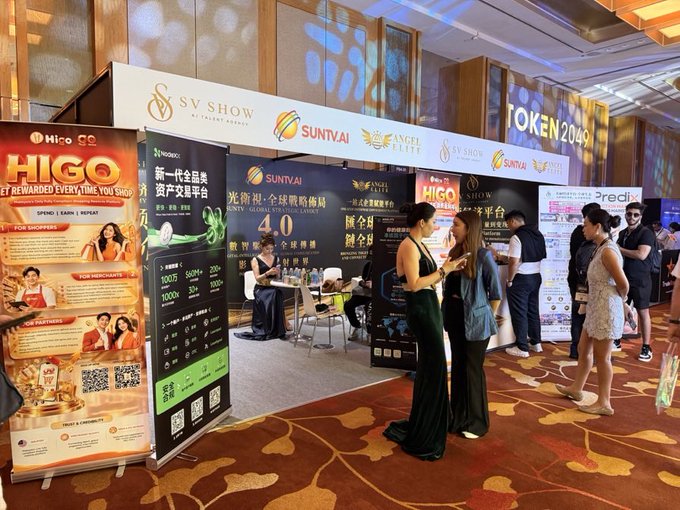 A convention or expo floor with attendees and booths for 'HIGO', 'SV SHOW', 'SUNTAI', and 'ANGEL ELITE', with people networking and walking by.