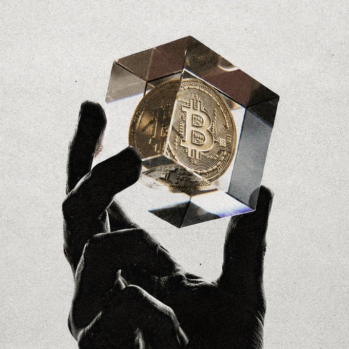 A black-and-white photo of a silhouetted hand holding a transparent cube containing a gold Bitcoin coin, with a grainy aesthetic.
