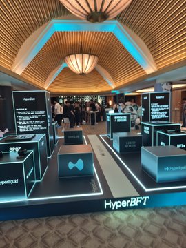 A HyperBFT exhibition booth at an event features illuminated displays labeled 'HyperBFT', 'BPFT', 'SFT', and 'SPY' under a blue-lit ceiling.