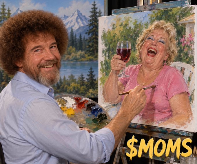 A Bob Ross-style painter with an afro and beard smiles while holding a paint palette, painting a portrait of a laughing woman in pink holding a wine glass, with '$MOMS' text overlay.