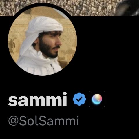 The image shows a social media profile for "sammi" (@SolSammi) featuring a circular profile picture of a man with a beard wearing a white head wrap, accompanied by a blue verified badge and what appears to be a Siri icon. The post celebrates earning a new badge, likely the verification checkmark visible on the profile.