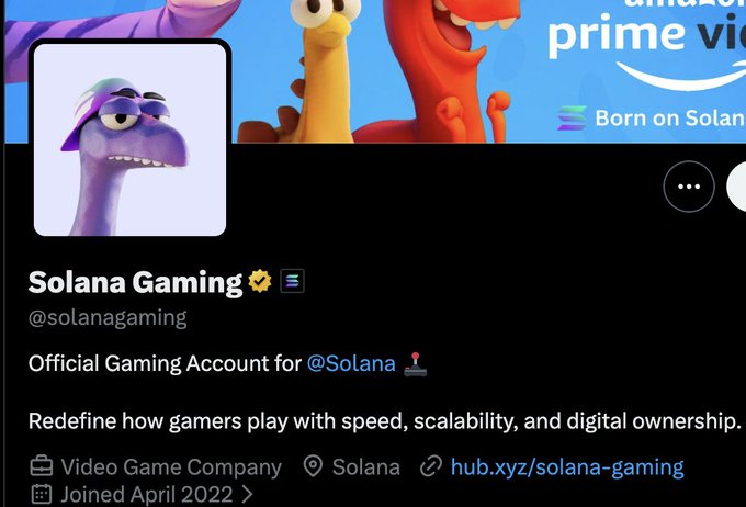 A verified Twitter/X profile for "Solana Gaming" (@solanagaming) displaying a purple dinosaur avatar wearing a white cap, with the bio "Official Gaming Account for @Solana" and the tagline "Redefine how gamers play with speed, scalability, and digital ownership." The dinosaur avatar in a hat ties into the post's reference to "the raptor in the solana hat," suggesting the commentator views Solana's mascot-branded gaming token as undervalued amid the ongoing crypto competitive dynamics.