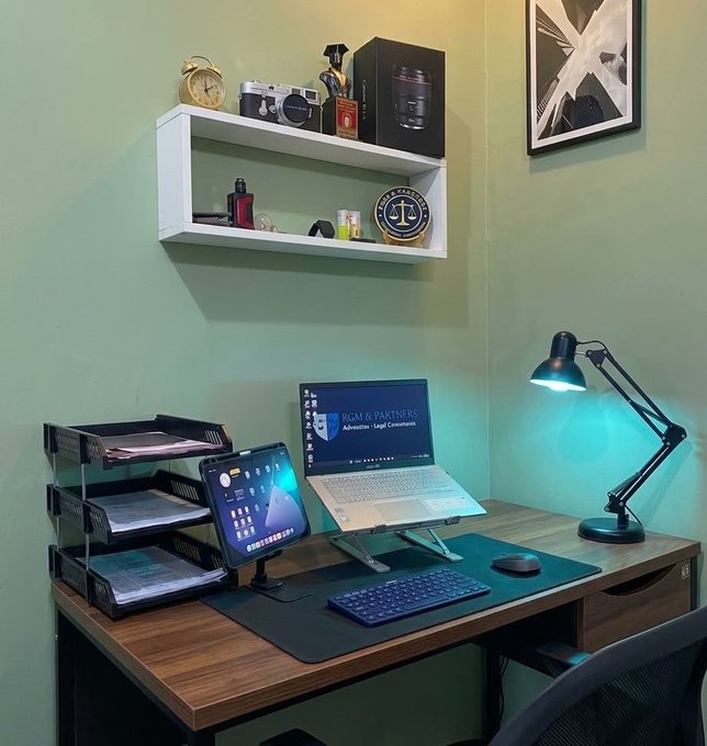 The image shows a desk with a laptop computer sitting on top of an apple-shaped mouse pad, surrounded by various items such as books, papers, and office supplies. A chair can be seen next to the desk, suggesting that this workspace is designed for productivity and comfort. The post about Ziggy Can I get a GM back? implies that there might be some sort of competition or challenge related to the name Ziggy Can. However, it seems unrelated to the main focus of the image - the office setup with the laptop computer on an apple mouse pad.
