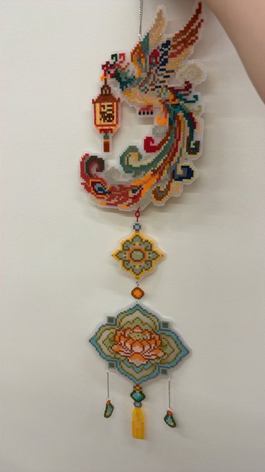 A colorful, intricately beaded Asian-style hanging ornament featuring a phoenix design at the top and decorative tassels dangling below, likely representing a symbol of good fortune or prosperity in Chinese culture. The image appears unrelated to the post's discussion about mental health qualifications for early retirement, creating a humorous juxtaposition between the ornate, traditional symbol of luck and the bleak outlook about needing a "backup plan" due to health and financial struggles.
