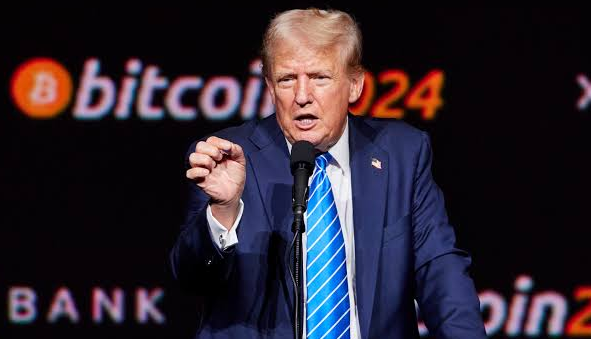 Donald Trump speaks at a podium with "Bitcoin 2024" signage in the background, his expression animated as he gestures mid-speech, visually reinforcing the post's claim about his family's significant stake in a Bitcoin mining operation.