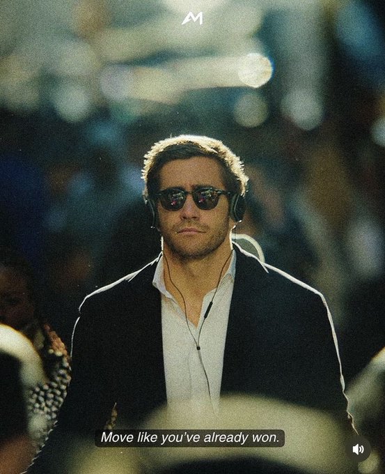 A man wearing sunglasses, a white shirt, and a dark blazer with headphones around his neck stands confidently with the motivational quote "Move like you've already won." displayed at the bottom.