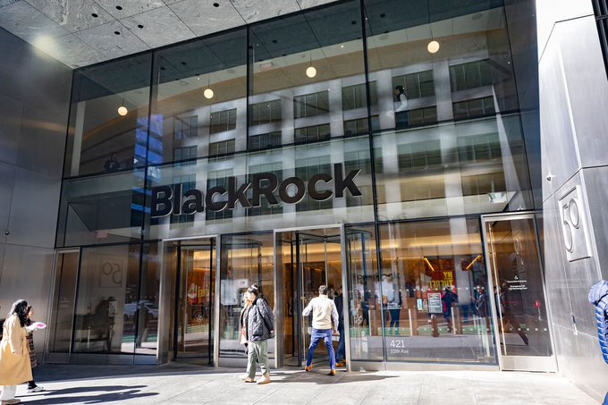 The exterior entrance of a BlackRock office building at 50 Hudson Yards (address 421) with the company name displayed prominently on the glass facade and people walking on the sidewalk.