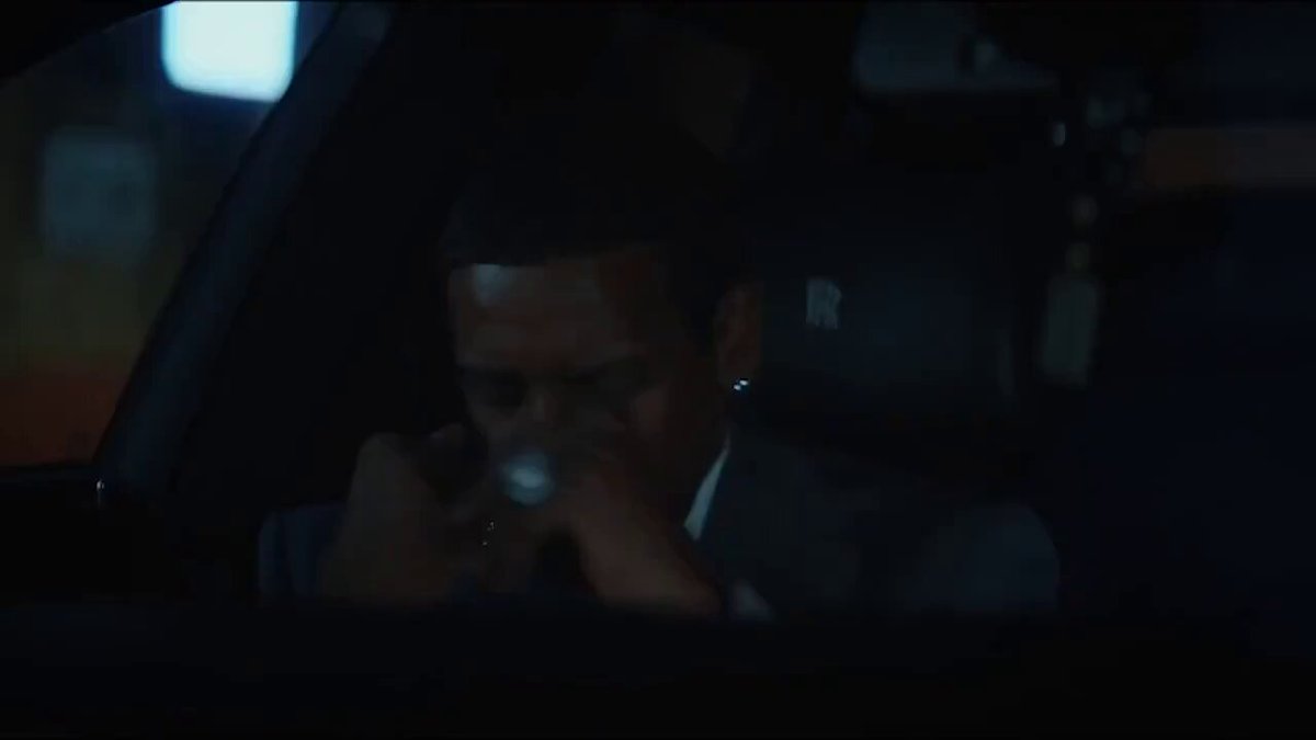 The image shows a man sitting inside a car with his eyes closed while looking at something outside of the vehicle, possibly a window or an object. The scene appears to be set in a dark environment, which adds to the overall moodiness of the image. The caption provided seems to be unrelated and does not provide any relevant information about the content of the image.