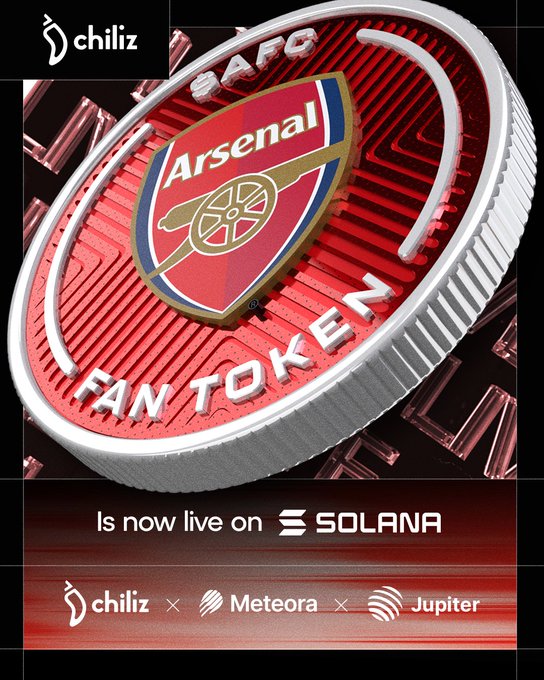 The image features a red coin with an Arsenal logo, which is now live on @Solana. The coin has been listed as a Fan Token on @JupiterExchange. The post also mentions that the AFC/USDC pools are available on @MeteoraAG and that the Arsenal Fan Token is now listed on @JupiterExchange.