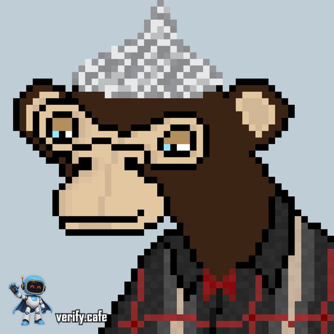 A pixel art illustration of a melancholic monkey wearing a foil hat and a dark robe with red accents, set against a light blue background. The watermark "verity.cafe" appears in the bottom left corner alongside a small robot mascot.
