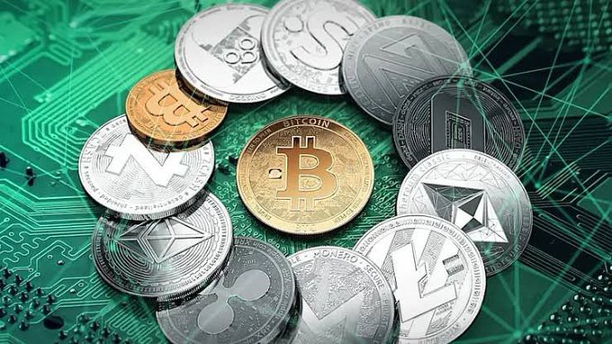 Various physical cryptocurrency coins—including Bitcoin, Monero, and Ethereum—rest on a green circuit board, visually symbolizing India's emerging regulatory framework for digital assets like the ones featured.