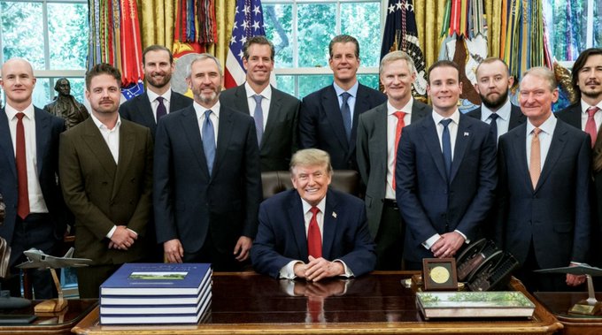A formal group photo taken in the Oval Office features President Donald Trump seated at the Resolute Desk, surrounded by a group of approximately 13 men in business attire, with American flags and presidential standards displayed in the background. The image visually connects to the accompanying post about Ripple CEO Brad Garlinghouse's statement regarding making America the crypto capital of the world, suggesting the photo depicts a meeting between the president and crypto industry executives.