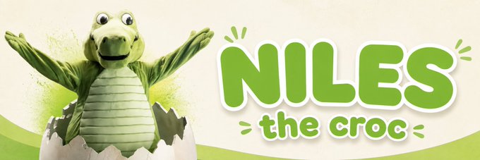 The image shows an animated crocodile mascot emerging from an eggshell with arms outstretched, alongside the text "NILES the croc" in green bubble letters. This illustrates the Crocs brand's newly revealed mascot "Niles," the same character that has appeared on the iconic Crocs footwear, supporting the post's claim about the brand finally naming their long-standing mascot.