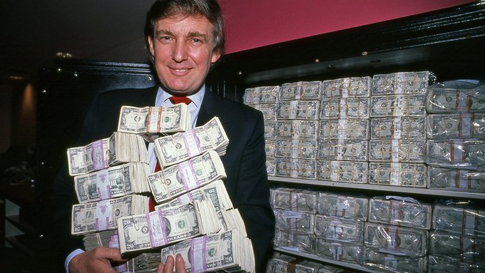 Donald Trump poses with stacks of US currency in front of a wall of money, a visual contrast to the news report stating he holds over $100 million in Bitcoin and ETH.