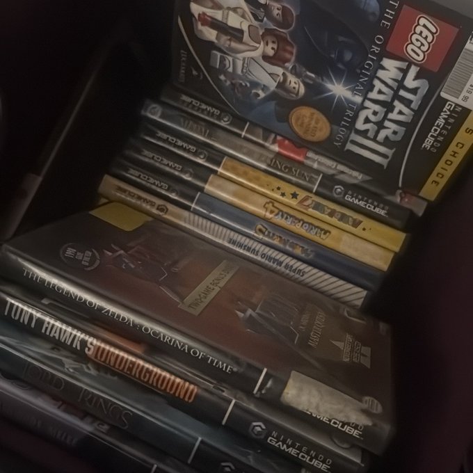 The image shows a collection of books stacked together, with some of them being video game cases for popular titles like Star Wars and Legend of Zelda. The books are arranged in various sizes and orientations, creating an interesting visual effect. The presence of these books suggests that someone has been collecting video games and gaming accessories, possibly as part of their hobby or passion for gaming.