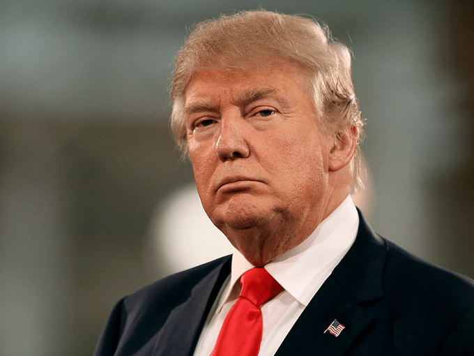 The image itself does not contain any explicit reference to cryptocurrency or the statement provided in the accompanying post. It features an older man dressed in formal attire, including a suit and a red tie with an American flag pin, which might symbolize patriotism or political affiliation. The serious expression on his face may be reflective of the gravity of financial matters being discussed in the post, such as the loss of value in Trump-linked crypto projects. The man's attire and demeanor could be interpreted as authoritative, which in the context of the post might suggest a sense of responsibility or leadership in financial matters, even though there is no direct textual connection to the man in the image and the financial issues mentioned.