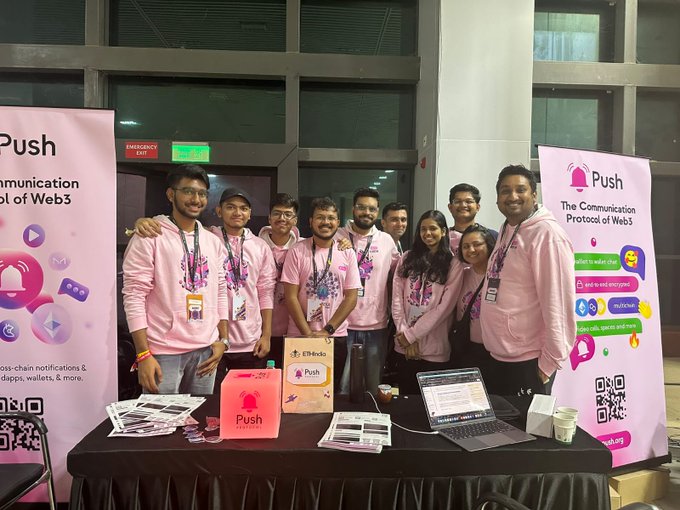 A team wearing pink Push Protocol hoodies poses at their booth at a Web3 conference, with banners reading 'Push - The Communication Protocol of Web3'.