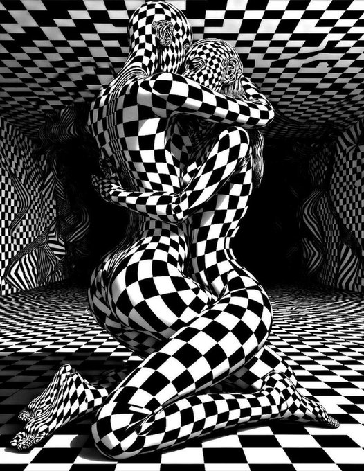 A surreal, black and white digital artwork featuring two figures with bodies covered in a distorted checkerboard pattern, intertwined in an embrace amidst a matching checkered landscape. The text "©2015 Daniel Torres" is visible in the bottom right corner.
