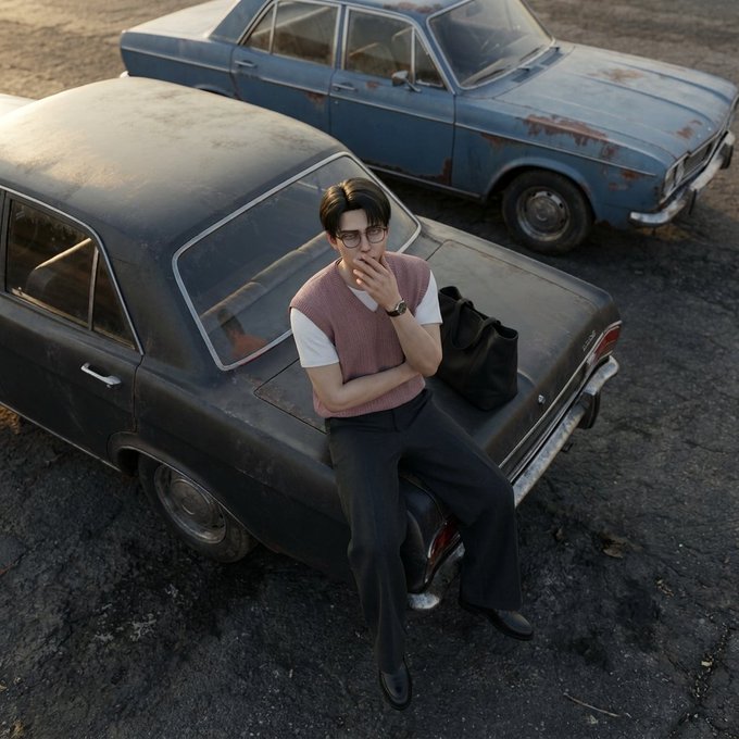 A stylized photograph of a young man wearing glasses, a pink sweater vest over a white shirt, and dark trousers, leaning against the trunk of a vintage dark-colored car, with a second rusty blue vintage car parked behind him.