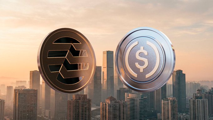 A conceptual image showing two large 3D cryptocurrency coins—one gold XLM (Stellar) and one silver USDC—hovering above a hazy cityscape at sunset.