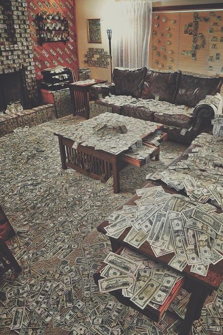 A living room is completely covered in scattered $100 bills across the floor, coffee table, and couch, with a large "$" symbol displayed on the window blinds. The image humorously illustrates the post "Crypto holders in 2027" by sarcastically depicting an absurdly wealthy crypto investor whose home is drowning in cash.