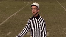 The image features an umpire dressed in a black and white striped shirt standing on a football field with his arms outstretched as if he's giving instructions or making a call during a game. The surrounding area appears to be a grassy field, which is typical for a football field setting. The post accompanying the image reads: "Verifiable randomness is like a referee for on-chain games: invisible when things go right, essential when they don't." This statement suggests that the umpire's role in the game might not always be immediately apparent or visible to everyone but is crucial for maintaining order and ensuring fair play.