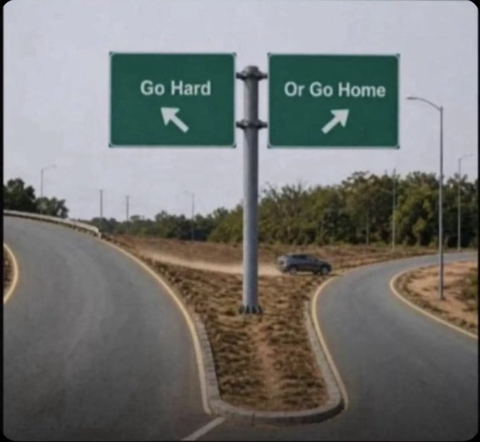 A fork in the road with two highway signs reading 'Go Hard' pointing left and 'Or Go Home' pointing right.