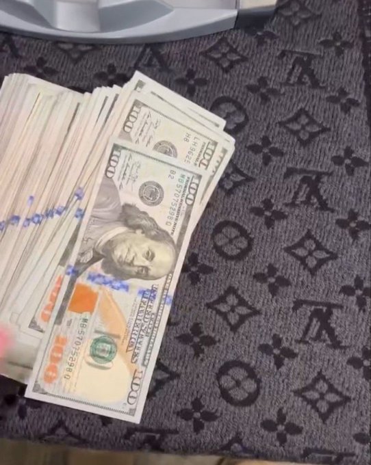 A fan of $100 US bills spread across a Louis Vuitton patterned surface, with serial numbers partially visible. The display of a substantial amount of cash visually reinforces the message "Get your money right."