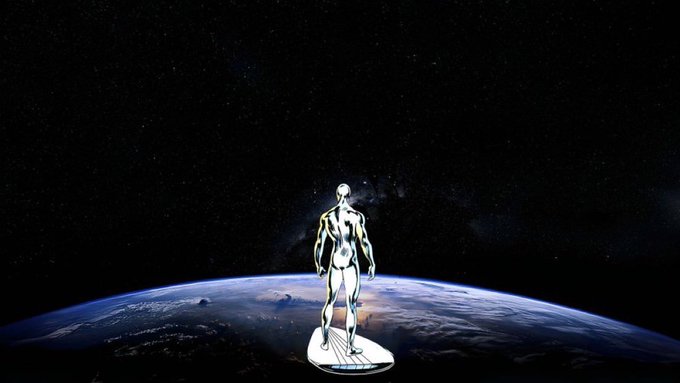 A metallic humanoid figure standing on a circular platform overlooking Earth from space, with the Milky Way galaxy visible in the starry black background.