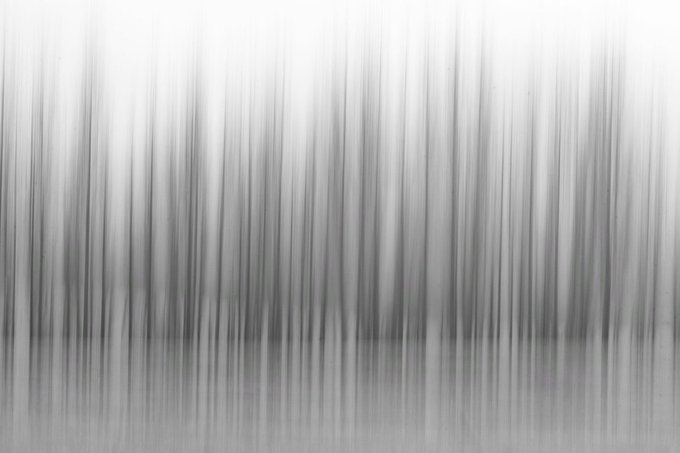 An abstract grayscale image with vertical blurred streaks fading from dark to light.