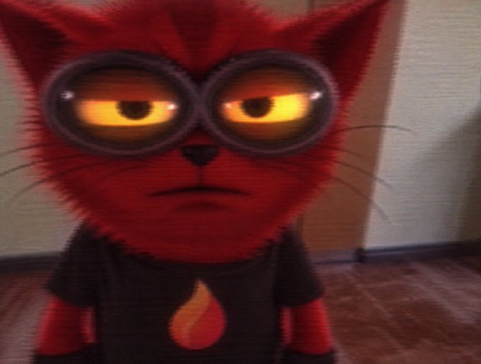 A close-up of a red furry cat character with glowing yellow eyes wearing a black shirt with a flame emblem, from an animated film.