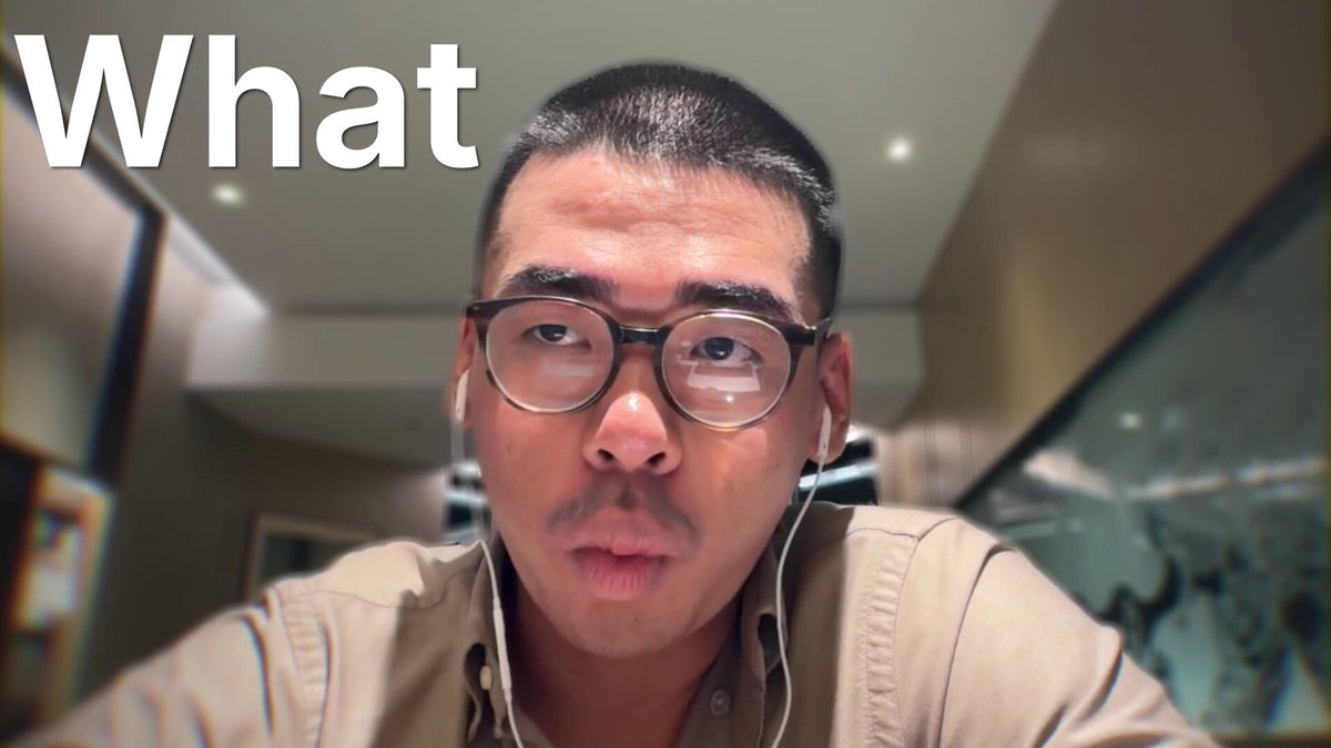 The image features a man wearing glasses with headphones around his neck, looking directly at the camera while holding a microphone. The caption of the image reads "What?". This suggests that the man might be participating in an online event or discussion related to the topic captured by the image.