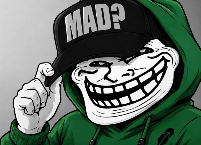 A stylized troll-face character wearing a green hoodie and a black cap tipped forward, with the text "MAD?" displayed on the hat. The image visually reinforces the "You Mad?" trolling meme by pairing the infamous smug troll face with the same phrase prominently featured on the cap.