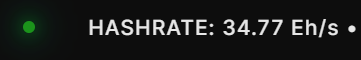 A digital display with a green indicator light shows the text 'HASHRATE: 34.77 Eh/s' in a blurry, glowing white font against a black background.