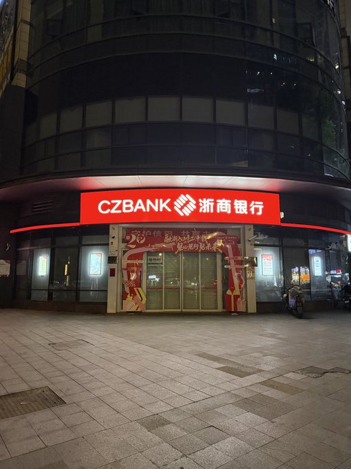 A nighttime photograph of a CZbank (浙商银行) branch with a red illuminated sign and Chinese New Year decorations on the entrance.