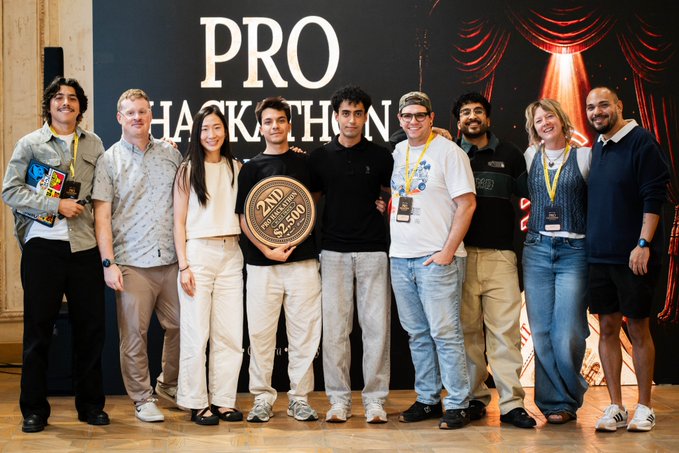 A group of nine people pose together in front of a "PRO HACKATHON" banner, with two members in the center holding a large "2ND" place trophy showing a $250 prize, celebrating their second-place win at the Rise In Web3 hackathon for building on Stellar with XoxnoNetwork.