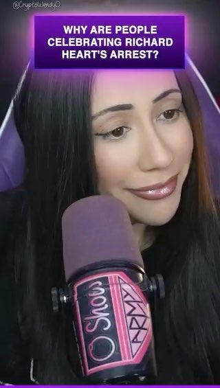 A woman with long dark hair speaks into a microphone, overlaid with a purple banner reading 'WHY ARE PEOPLE CELEBRATING RICHARD HEART'S ARREST?' and the handle '@CryptoWendyO'.