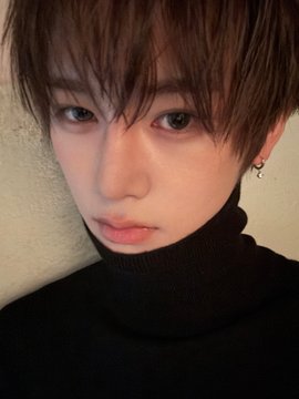 A close-up portrait of a young man with tousled brown hair, wearing a black turtleneck and a small hoop earring, set against a plain beige wall. The image accompanies a post featuring hashtags "#ALPHADRIVEONE #ALD1#알파드라이브원#ANXIN #안신," likely promoting the K-pop group or its member with a moody, intimate aesthetic.