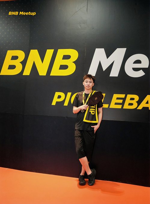 Person posing at a BNB Meetup event in front of a 'BNB ME' and 'PI...LEBA...' branded wall.