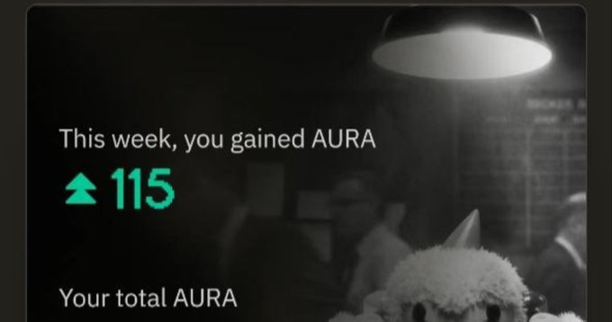 A notification card displays the text "This week, you gained AURA +115" and "Your total AURA" against a dark background featuring a plush toy.
