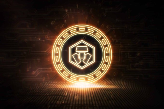 The image features a large circular logo with a hexagon at its center, glowing with an orange light against a dark background. The text "Good morning, Cronos! I'Mbullish ON $CRO" is written below the logo in white letters. This suggests that the image might be related to cryptocurrency or blockchain technology, as the name "Cronos" and the use of the word "bullish" indicate a positive sentiment towards the subject matter. The glowing hexagon symbolizes the energy and excitement associated with cryptocurrencies like Bitcoin.